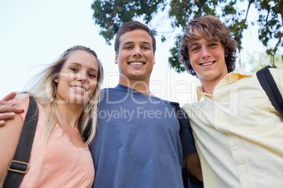 Low angle-shot of three students shoulder to shoulder