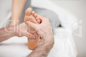 Man using his two hands to massage a foot