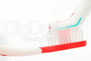 Red toothbrush with multicolour toothpaste