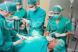 Nurse giving a surgical tool to a surgeon