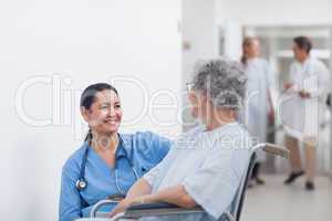 Nurse looking at a patient in a wheelchair