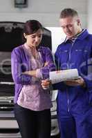 Mechanic showing the quotation to a woman