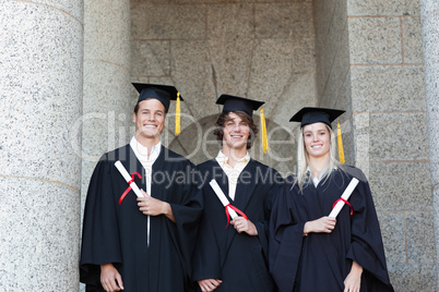 Portrait of graduates holding their diploma