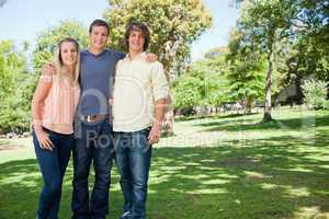 Portrait of three smiling students shoulder to shoulder