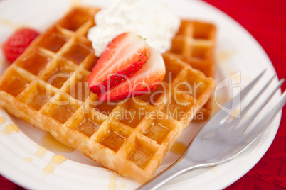 Waffles with whipped cream and strawberry on it