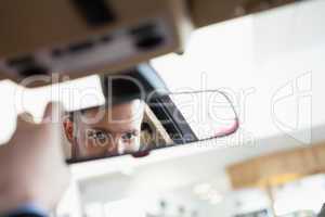 Man looking in an interior car mirror