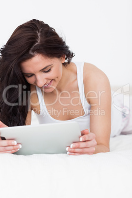 Smiling brunette woman looking at her tablet computer