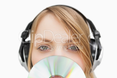 Close up of a woman with a cd in front of her face