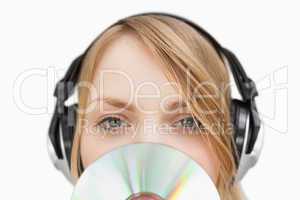 Close up of a woman with a cd in front of her face