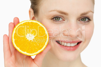 Blond-haired woman presenting an orange