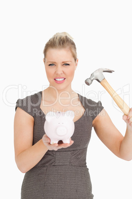 Concentrated woman want to break a piggy bank