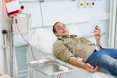 Transfused patient holding a tablet computer