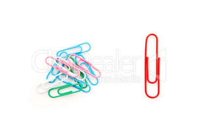 Big red paper clip and many paper clips side by side