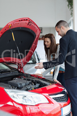 Salesman showing the car engine