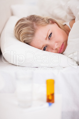 Sick young woman with medicines