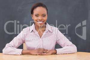 Teacher smiling while putting her hands on desk