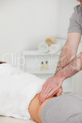 Woman lying while a physiotherapist is massaging her back