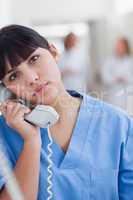 Nurse looking at camera while holding a phone
