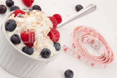 Jar of fruits and whipped cream with spoon and tape measure