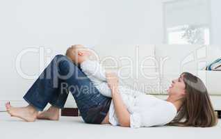 Mother lying on the floor with a baby
