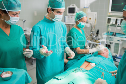 Surgeons standing next to a patient