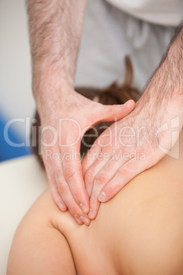 Doctor pressing the side of the back of his patient while standi