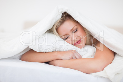 Blonde resting while embracing her pillow