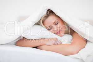 Blonde resting while embracing her pillow