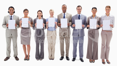 Business people smiling while holding support for letters
