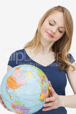 Woman holding a globe while looking it