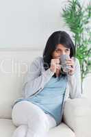 Woman drinking from a grey mug