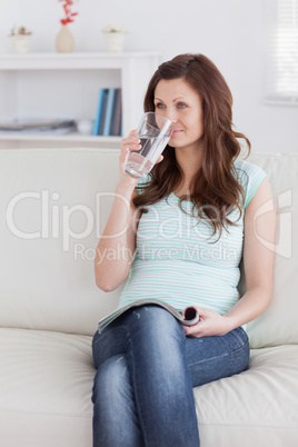 Woman drinking while sitting on a sofa