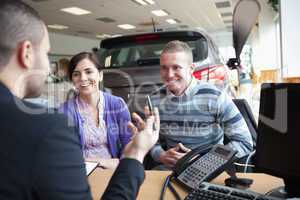 Couple smiling while talking with a salesman