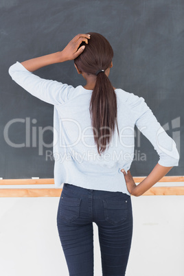 Black woman thinking in front of a blackboard