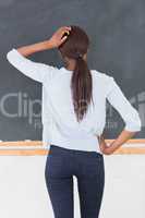 Black woman thinking in front of a blackboard