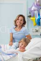 Child lying on a bed next to his mother