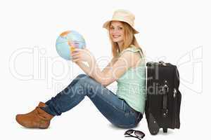 Woman smiling while holding a world globe