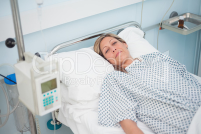 Female patient lying on a bed while looking at camera