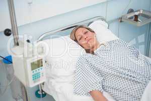 Female patient lying on a bed while looking at camera