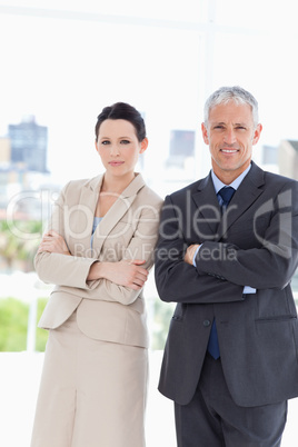 Young secretary standing upright next to her director