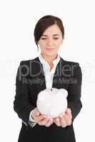 Businesswoman looking at a piggy-bank