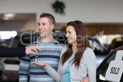 Salesman giving car keys to a woman