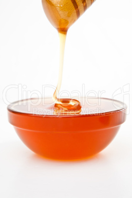 Honey trickle dropping in full honey bowl