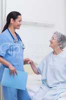 Elderly patient holding the hand of a nurse
