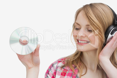 Woman holding a cd while listening music