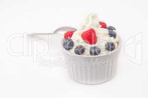 Jar of berries and whipped cream with spoon