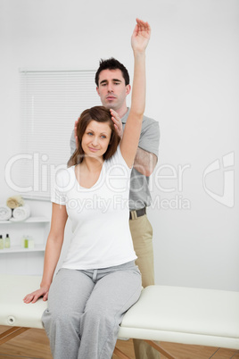 Peaceful woman raising her arm while being manipulated