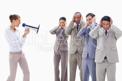 Woman yelling through a megaphone at business people covering th