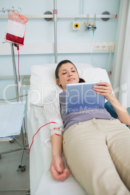 Female transfused patient holding a tablet computer