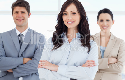 Young smiling executive woman crossing her arms in front of two